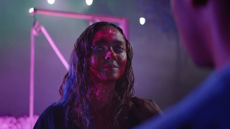 Lavinia in violet and magenta cinematic light.